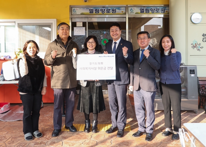 김진경(오른쪽 3번째) 경기도의회 의장과 장대석(민주·시흥2·오른쪽 2번째) 경기도의원, 시흥 엘림양로원 관계자들이 21일 엘림양로원 앞에서 기념촬영을 하고 있다. (사진=경기도의회 제공)