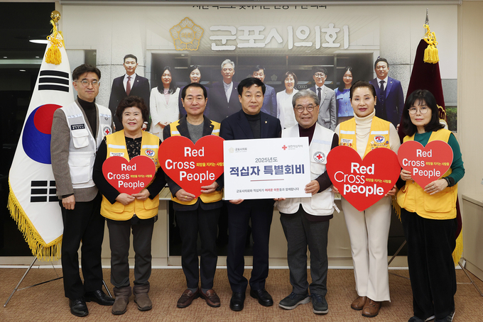 20일 군포시의회 김귀근 의장(가운데)이 대한적십자사 경기도지사 이재정 회장에게 2025년도 특별회비를 전달하고 있다. (사진=군포시의회 제공)