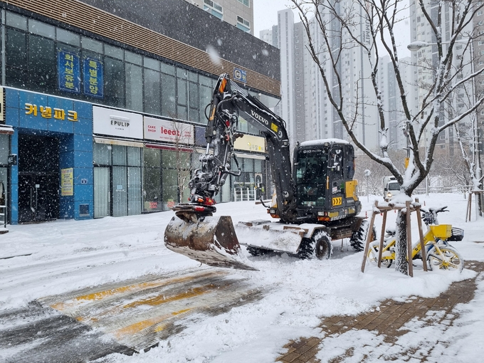 수원시가 굴삭기를 활용해 이면도로에서 제설 작업을 하고 있다. (사진=수원시 제공)