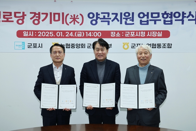 하은호 군포시장(가운데)과 이상복 농협중앙회군포시지부장, 이명근 군포농업협동조합장이 경로당 경기미 협약서를 들어보이고 있다.(사진=군포시 제공)