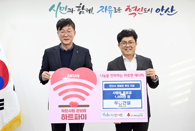 기부금 전달 후 기념사진을 촬영 중인 이민근 안산시장(왼쪽)과, 오세욱 두산건설 상무. (사진=두산건설 제공)