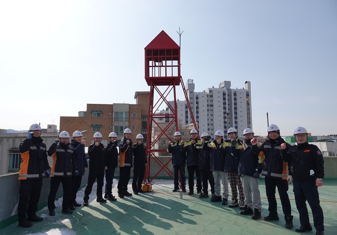 경기도 119 특수대응단 소속의 직원들이 소방 사이렌 탑 앞에서 기념촬영을 하고 있다. (사진=안성소방서 제공)