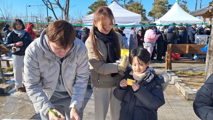 정월대보름행사에 자녀와 함께 안녕을 기원하며 소원을 쓰고 있다. (사진=고촌읍사무소 제공) 