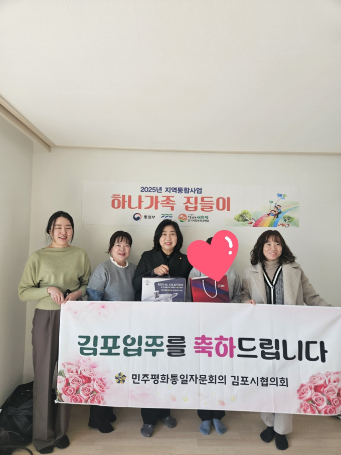 민주평통 김포시협의회 관계자들이 김포시에 전입해 온 북한 이탈주민 세대를 방문해 집들이 행사에서 기념사진을 찍고 있다. (사진=민주평통 김포시협의회제공)