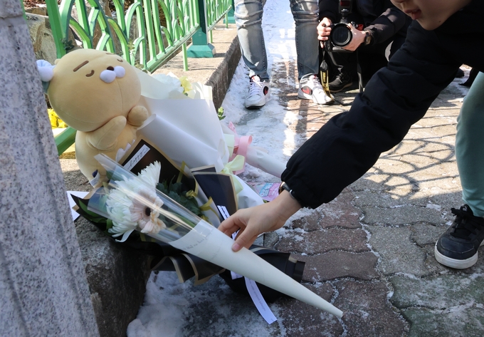 11일 오전 초등학교 1학년 김하늘 양(8)이 살해당한 대전 서구 한 초등학교 앞에서 한 아동이 국화꽃을 두고 추모하고 있다. (사진=연합뉴스)