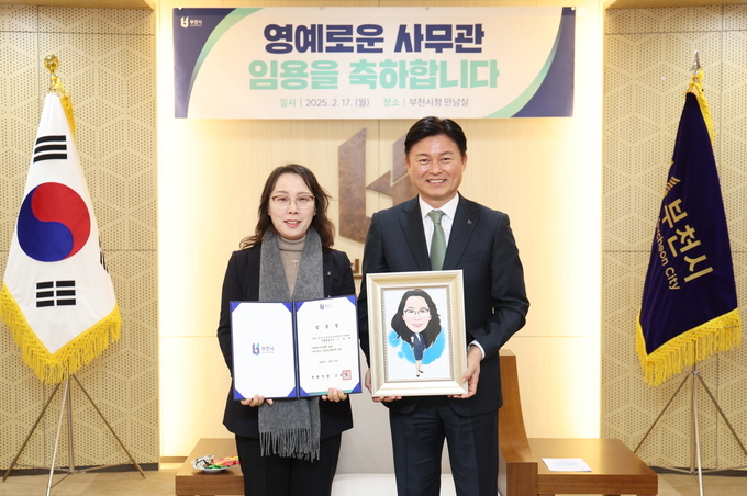 조용익 부천시장과 조월매 스마트도시과장이 5급 승진 임용장과 캐리커처를 들고 기념촬영을 하고 있다. (사진=부천시 제공)