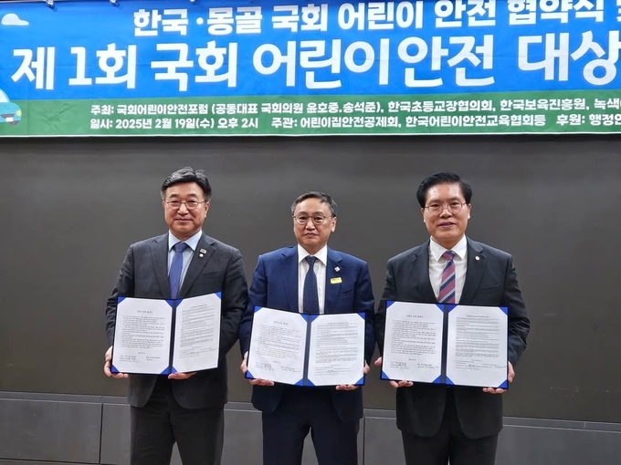 국회어린이안전포럼 공동대표인 윤호중·(왼쪽)송석준 의원(오른쪽)이 19일 칭브런 몽골 국회의원(가운데)과 한-몽골 어린이 안전 협약식을 갖고 협약서를 들어 보이고 있다. (사진=송석준 의원실 제공)