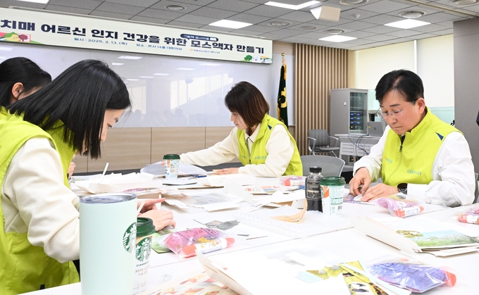 송춘수 대표이사(오른쪽)를 비롯한 ‘헤아림 봉사단’이 공기정화액자를 만들고 있다. (사진=NH농협손해보험 제공)