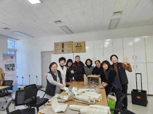 주민들이 환경보호를 위해 종이컵,우유팩, 폐건전지 등을 모아 고촌읍에 전달하고 기념사진을 찍고 있다. (사진=고촌읍사무소 제공)