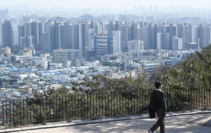 지난달 26일 수원시 서장대에서 두꺼운 패딩을 입은 시민이 산책을 하다 따뜻해진 날씨에 외투를 어깨에 걸치고 산책을 하고 있다. (사진=옥지훈 기자)
