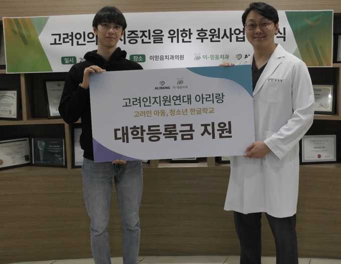 고려인 학생들을 위한 대학등록금 지원 프로그램 후 심우철 이믿음치과 원장(오른쪽)과 학생이 기념촬영을 하고 있다. (사진=이믿음치과 제공)