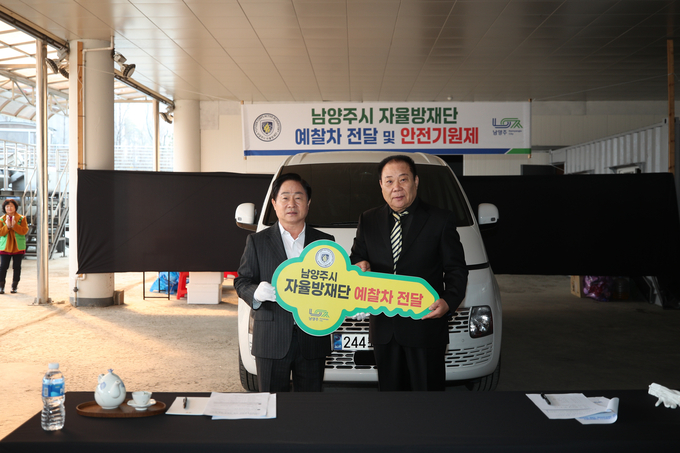  주광덕 남양주시장이 10일, 지역자율방재단 권영수 단장에게 차량 키를 전달하고 기념촬영을 하고 있다. (사진=남양주시 제공)
