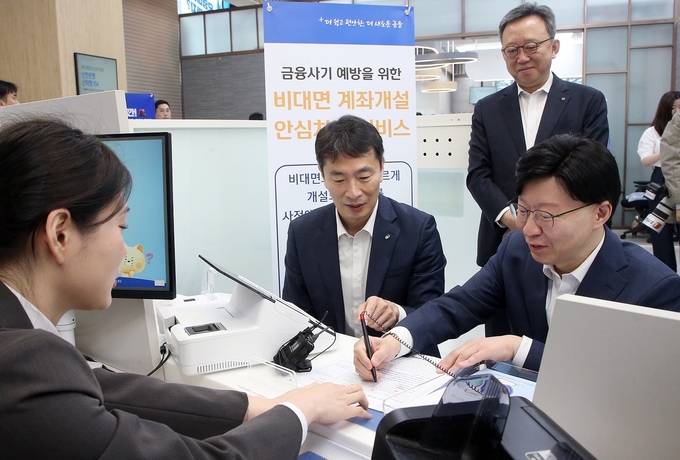 (왼쪽부터) 이복현 금융감독원장, 정상혁 신한은행장, 김소영 금융위원회 부위원장이 ‘금융권 비대면 계좌개설 안심차단 서비스 간담회' 이후 서비스에 대한 직원의 설명을 듣고 있다. (사진=신한은행 제공)