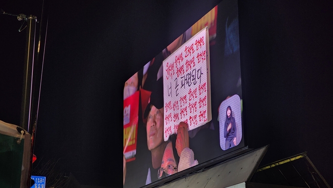  14일 서울 안국역 1번 출구 인근에서 진행된 촛불행동의 집회에서 참가자가 윤석열 대통령 탄핵을 촉구하는 메시지가 화면에 잡혔다. (사진=박진석 기자)