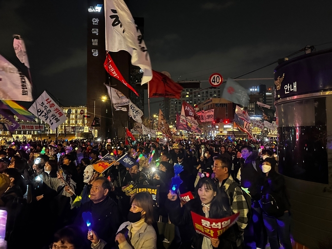 윤석열 대통령 탄핵촉구 집회참가자들이 노래에 맞춰 야광봉과 깃발을 흔들고 있다. (사진=박희상 수습기자)
