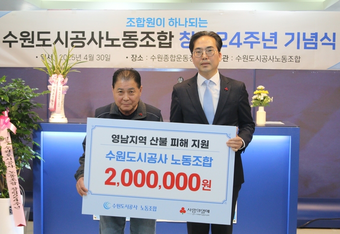 수원도시공사 노동조합 산불 피해 지원 성금 전달식 후 엄기천 조합장(왼쪽)과 김효진 경기 사랑의열매 사무처장이 기념촬영을 하고 있다. (사진=경기 사랑의열매 제공)