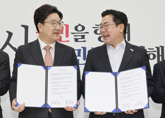 1일 서울 여의도 국회에서 박찬대 더불어민주당 당대표 직무대행 겸 원내대표(오른쪽)와 권성동 국민의힘 원내대표가 추경안 합의문에 서명한 뒤 미소짓고 있다.. (사진=연합뉴스)