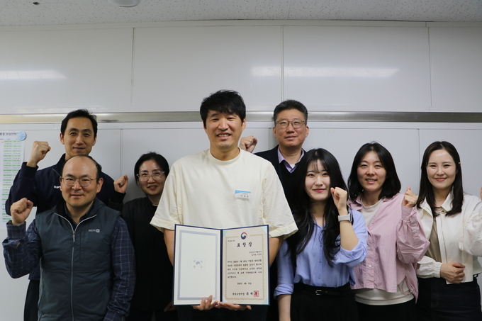 분당소방서로부터 ‘민간인 현장활동 유공자’ 표창을 받은 수영강사 이영준 씨(가운데 흰색 티셔츠)가 동료들과 함께 기념촬영을 하고 있다. 이 씨는 심정지 환자에 대한 신속한 응급조치로 생명을 살린 공로를 인정받았다. (사진=분당소방서 제공)