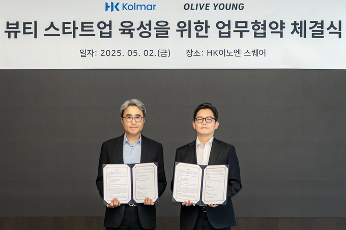 허현행 한국콜마 경영기획본부장(왼쪽)과 장지민 CJ올리브영 경영지원담당이 기념 사진을 찍고 있는 모습 (사진=CJ올리브영 제공)