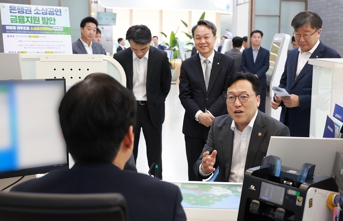 김병환 금융위원장이 8일 신한은행 본점 영업부에서 ‘은행권 소상공인 금융지원 현장 간담회’에서 직원의 설명을 경청하고 있다. (사진=신한은행 제공)
