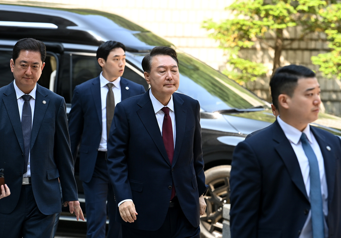  윤석열 전 대통령이 12일 오전 서울 서초구 중앙지방법원에서 열린 내란 우두머리 혐의, 직권남용 권리행사방해 혐의 사건 3차 공판에 출석, 취재진의 질문을 받으며 이동하고 있다. (사진 = 사진공동취재단)