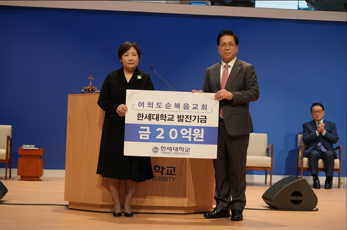 여의도순복음교회를 대표해 이영훈 목사가 20억 원의 발전기금 후원 의사를 담은 기념 패널을 백인자 한세대 총장에게 전달하고 있다.(사진=한세대 제공)