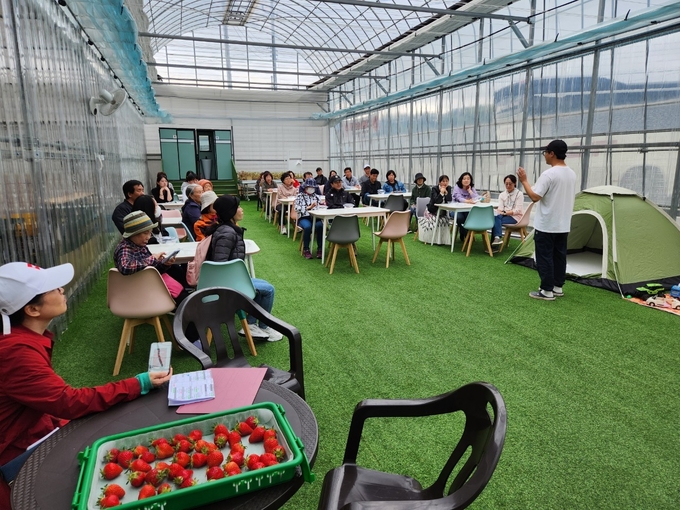 안성시는 시티투어버스도 운영하며 관광객 편의성을 높이고 있다. 사진은 관광객들이 딸기수확체험에 관한 설명을 듣고 있는 모습. (사진=안성시 제공)