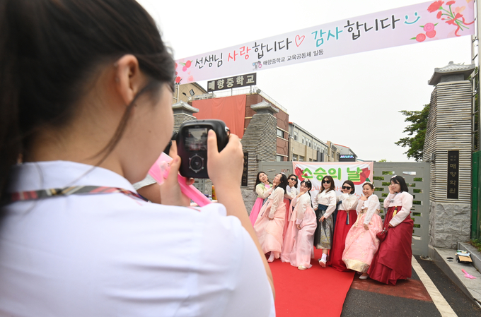 스승의날을 맞은 15일 오전 수원시 매향중학교에서 학생들이 '스승의날 레드카펫 행사'를 열고 출근하는 선생님을 맞이한 뒤 기념촬영을 하고 있다.