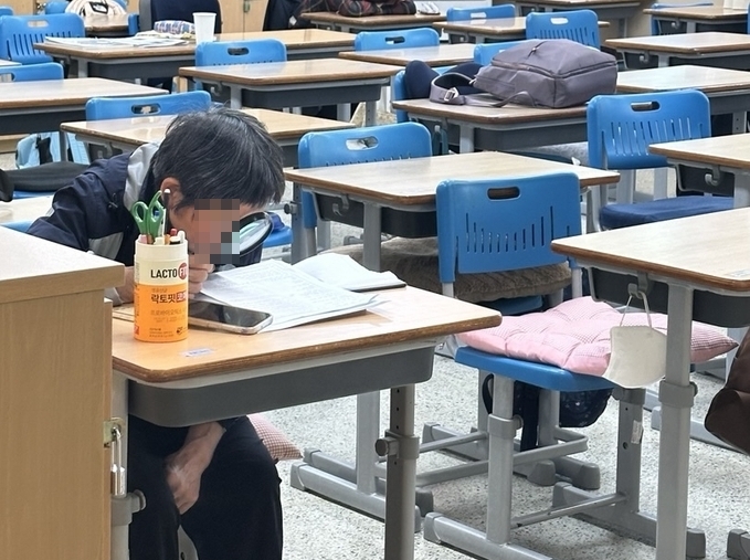 계명고등학교 교실에서 한 학생이 돋보기를 이용해 교과서를 읽고 있다. (사진=박민정 기자)