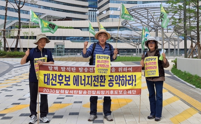 이원영(가운데) 원전위험공익정보센터 대표와 탈탈탈기후순례단 단원들이 지난 19일 오후 경기도청 앞에서 행진을 마치고 기념촬영을 하고 있다. (사진=탈탈탈기후순례단 제공)