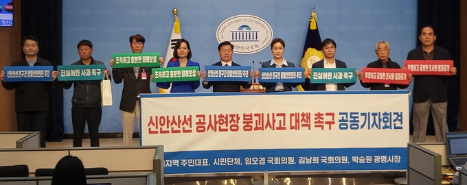 20일 국회 소통관에서 열린 신안산선 공사현장 붕괴사고 대책 촉구 공동기자회견 참석자들이 피해주민의 요구 사항이 적힌 손피켓을 들고 있다. (사진=한주희 수습기자) 
