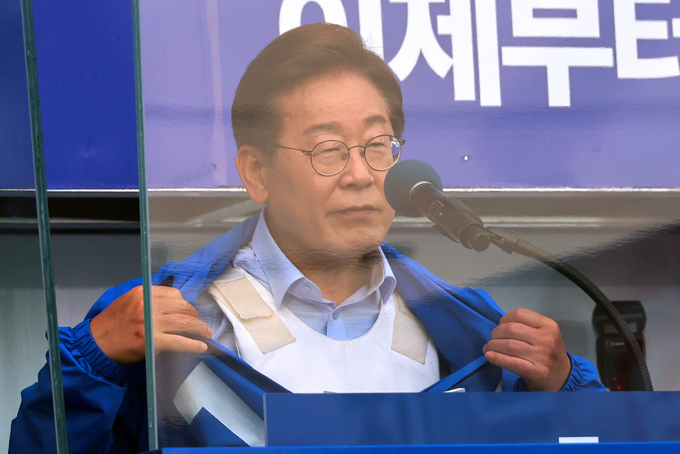 이재명 더불어민주당 대선 후보가 21일 자신의 지역구인 인천광역시 계양역 앞 유세에서 방탄유리, 방탄조끼 비판에 대해 항변하던 중 점퍼 속 방탄조끼를 보여주고 있다. (사진=연합뉴스)