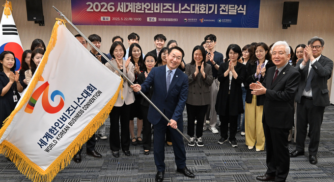 22일 재외동포웰컴센터에서 열린 '2026 세계한인비즈니스대회기 전달식'에서 이상덕 재외동포청장에게 대회기를 전달받고 있다.