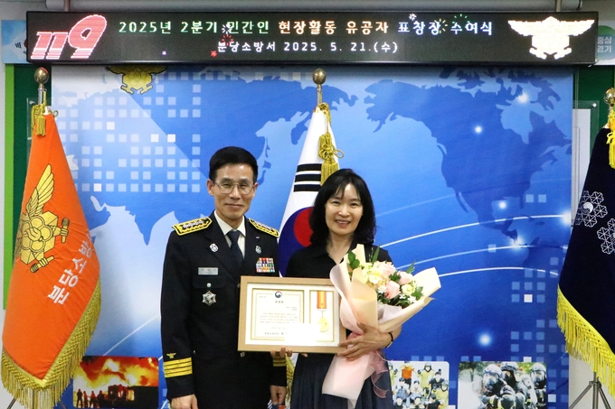 분당소방서에서 열린 ‘2분기 민간인 현장활동 유공자 표창장 수여식’에서 유재홍 분당소방서장이 생활안전 기여 공로로 표창을 받은 이영애(62) 씨와 함께 기념촬영을 하고 있다. 이 씨는 탄천 산책로에서 위험 요소를 발견하고 시민의 안전을 지키는 데 적극적으로 나서 표창을 받았다. (사진=분당소방서 제공)