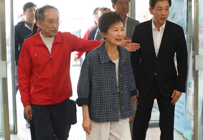 박근혜 전 대통령이 제21대 대통령선거 사전투표 첫날인 29일 대구 달성군 유가읍행정복지센터에 마련된 사전투표소에서 추경호(왼쪽), 유영하 국민의힘 의원(오른쪽)과 함께 이동하고 있다. (사진=연합뉴스)