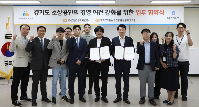 김민철 경기도시장상권진흥원장(가운데 오른쪽)과 정재훈 ㈜소프트먼트 공동대표(가운데 왼쪽)가 29일 오후 양평 경상원 본원 대교육장에서 ‘경기도 소상공인 경영 여건 강화를 위한 업무 협약'을 체결한 뒤 기념촬영을 하고 있다. (사진=경상원 제공)