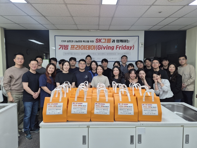 성남 도촌종합사회복지관에서 열린 ‘기빙 프라이데이(Giving Friday)’ 행사에 참여한 SK그룹 6개사 임직원들이 직접 준비한 밑반찬 꾸러미를 앞에 두고 기념촬영을 하고 있다. 이날 행사는 지역 내 저소득 장애인 및 홀몸 어르신 50가정을 위한 나눔 활동으로 진행됐다. (사진=도촌종합사회복지관 제공)