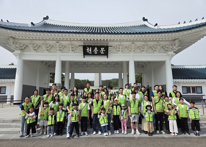 현대엔지니어링 임직원 및 임직원 가족이 국립서울현충원에서 묘역 정화 봉사활동을 한 뒤, 기념촬영을 하고 있다. (사진=현대엔지니어링 제공)
