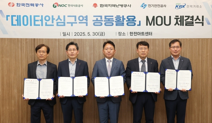30일 서울 한전아트센터에서 열린 ‘데이터 안심구역 공동활용 MOU 체결식’에서 관계자들이 협약서를 들어 보이고 있다. (왼쪽부터_ 전력거래소 김홍근 전력계통본부장, 한국지역난방공사 고국현 경영지원본부장, 한국전력 문일주 기술혁신본부장, 한국석유공사 신용화 경영지원본부장, 한국전기안전공사 배계섭 안전이사. (사진=한국지역난방공사 제공)