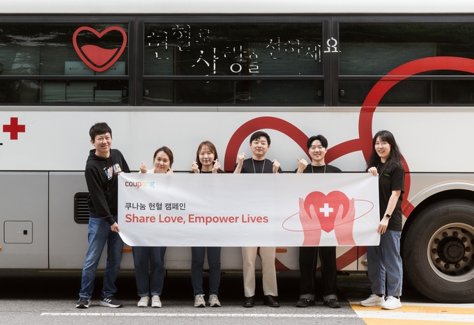 쿠팡 잠실 사옥 부근 헌혈버스 앞에서 ‘쿠나눔 헌혈 캠페인'에 참여한 쿠팡 임직원들이 기념사진을 촬영하고 있다. (사진=쿠팡 제공)