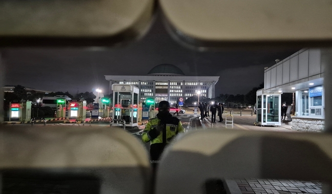 비상계엄이 선포된 지난해 12월 3일 밤 국회 출입구에 경찰이 서있다. (사진=김한별 기자)