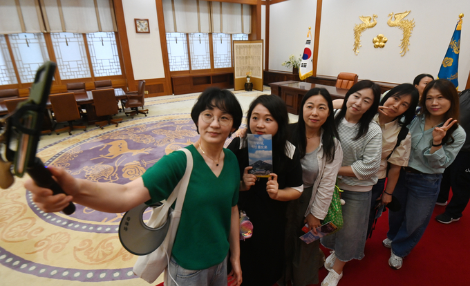 제21대 대통령선거 본투표를 하루 앞둔 2일 서울 종로구 청와대에서 관람객들이 대통령 집무실을 배경으로 기념촬영을 하고 있다.