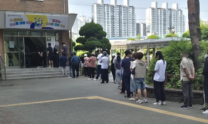 인천 계양구 서운중학교 투표소를 찾은 유권자들의 대기줄이 길게 이어져 있다. ( 사진 = 이현도 기자 )