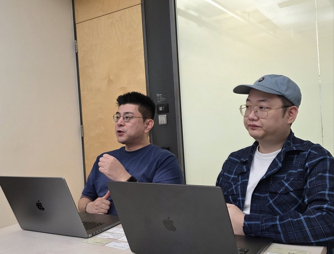 지난달 27일 NHN 사옥에서 만난 김동선 총괄 PD(좌)와 정중재 게임사업실장(우). 김 PD가 게임을 설명하고 있다. (사진=이효정 기자)