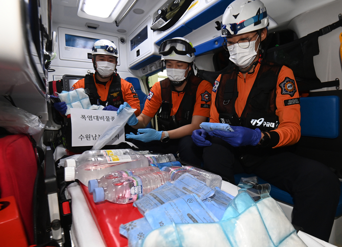 무더운 날씨가 이어진 9일 수원시 권선구 수원남부소방서에서 남부119안전센터 이윤호 소방장, 백지민 소방교, 이진성 소방사가 얼음조끼와 아이스팩 등 폭염 대비 물품을 점검하고 있다.