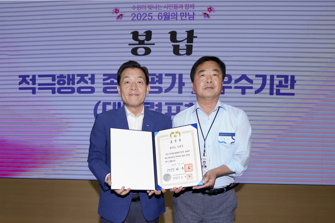 전용기 수원시 법무담당관이 지난 9일 시청 중회의실에서 열린 ‘6월의 만남’ 행사 중에 이재준 수원시장(왼쪽)에게 대통령 표창을 봉납하고 있다. (사진=수원시 제공)