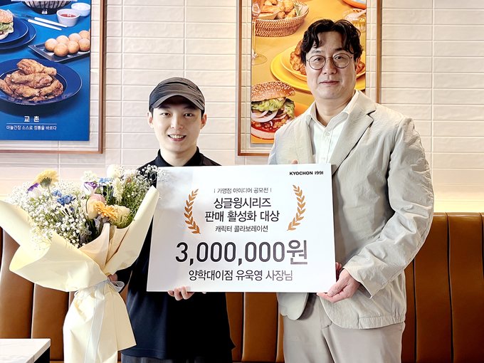 유욱영 교촌치킨 양학대이점주(왼쪽)가 경북 포항 ‘교촌치킨 양학대이점’에서 진행된 싱글윙 시리즈 판매 활성화 아이디어 공모전 시상식에서 이상로 교촌에프앤비 국내사업부문장(오른쪽)으로부터 ‘싱글윙시리즈 판매 활성화 대상’을 수상하고 기념사진을 촬영하고 있다. (사진=교촌에프앤비 제공)
