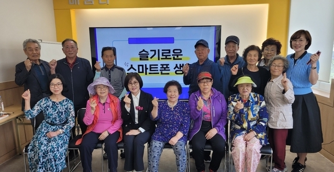 지난달 26일 경기도 포천시 관인면 작은도사관 ‘AI 사랑방’에서 진행된 슬기로운 스마트폰 생활 교육에서 참여 어르신들이 기념촬영을 하고 있다. (사진=경기도 제공)