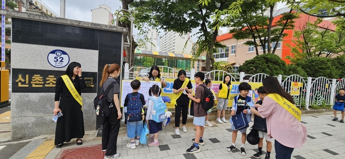 고양 신촌초 학부모회가 등하교 학샏들을 상대로 등굣길 교통안전 캠페인을 벌이고 있다. (사진=신촌초 제공)<br>
