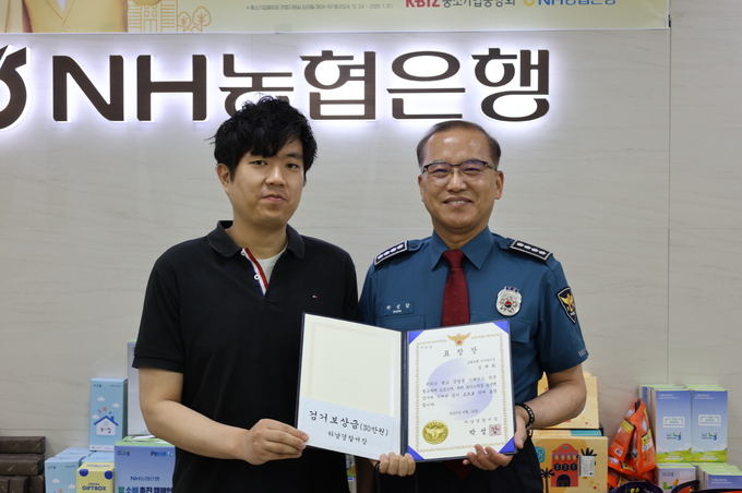 박성갑 서장이 보이스 피싱 범죄를 막은 농협 미사역지점 김대희 계장과 표장장을 수여식 기념촬영을 하고 있다. (사진=하남서 제공) 
